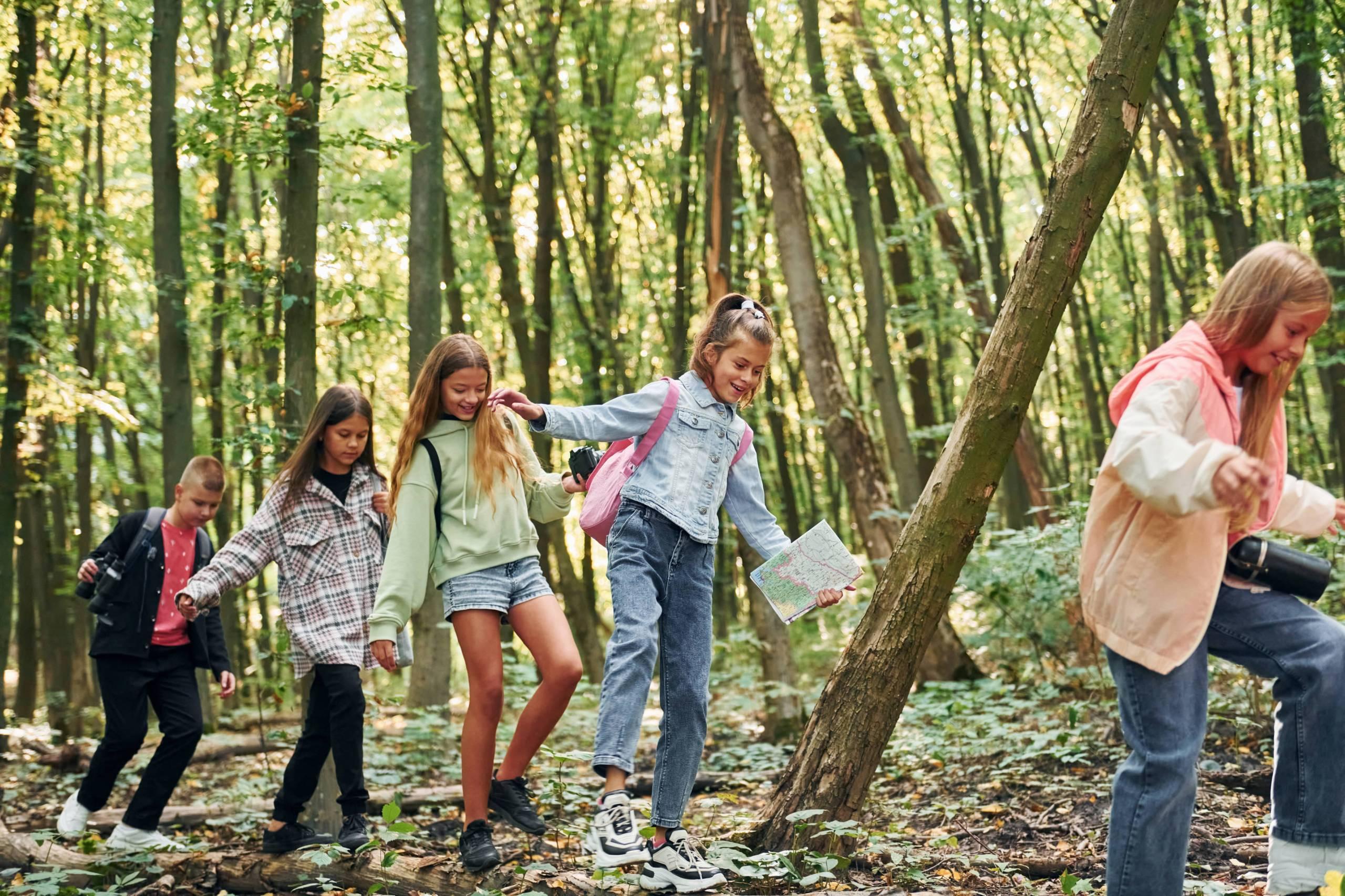 walking-on-the-log-kids-in-green-forest-at-summer-2021-12-23-00-56-48-utc